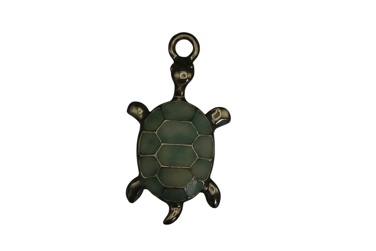 close-up of green enamel turtle charm on black background