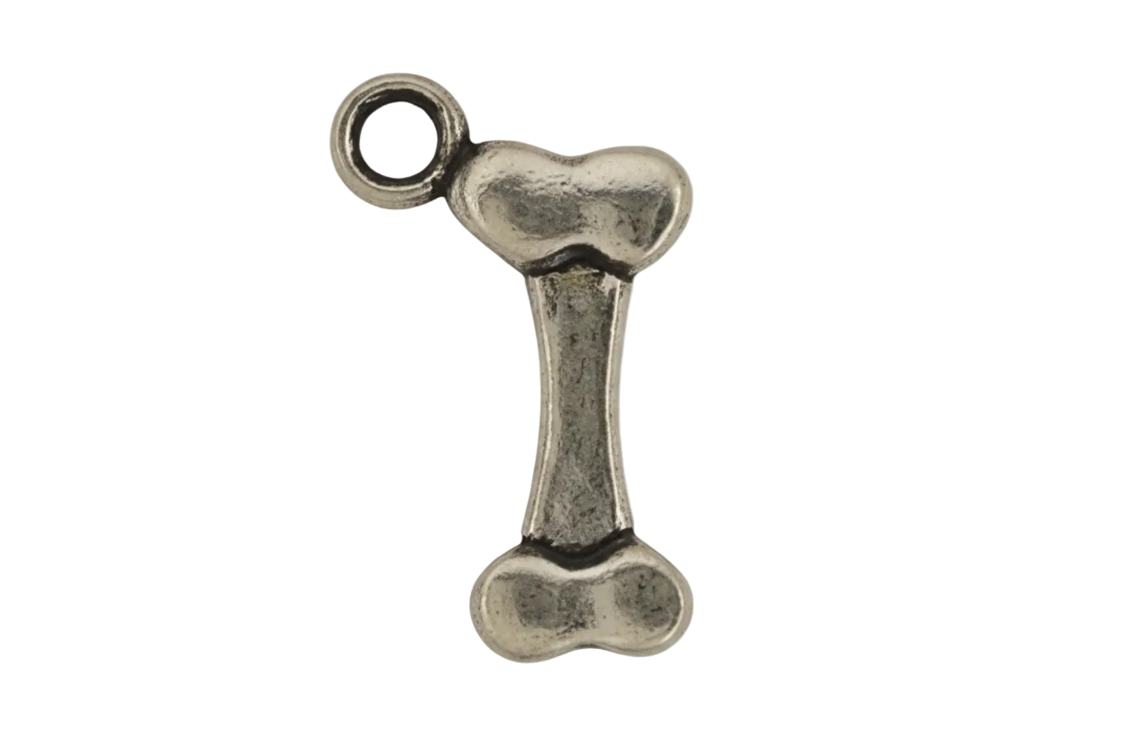 close-up of an antique silver bone-shaped charm on a black background