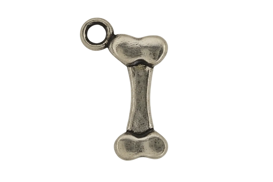 close-up of an antique silver bone-shaped charm on a black background