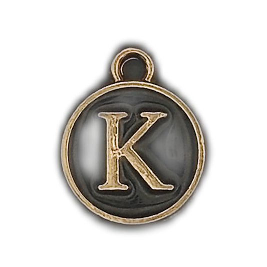close-up of round black and gold charm with letter K