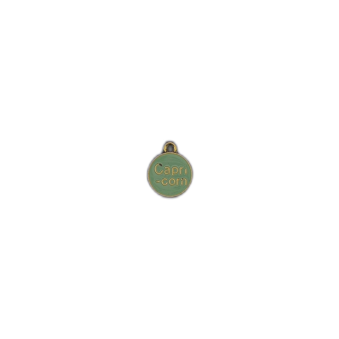 small green round Capricorn charm centered on a black background