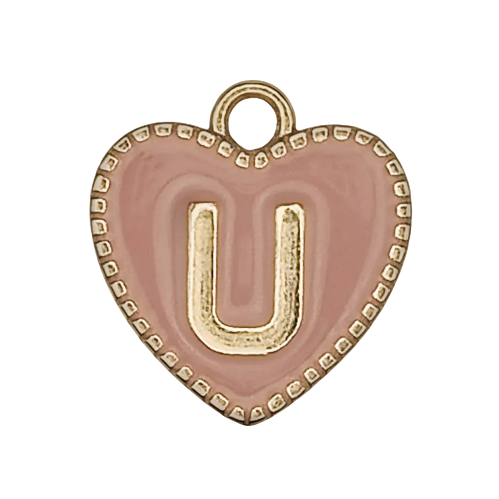 close-up of a pink heart charm with a raised gold letter U