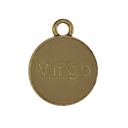 close-up of a round gold-tone charm engraved with Virgo on a black background