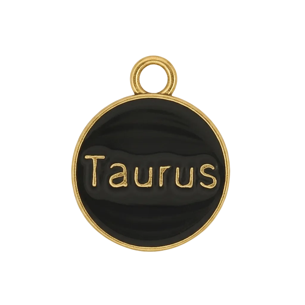 close-up of round black and gold Taurus charm