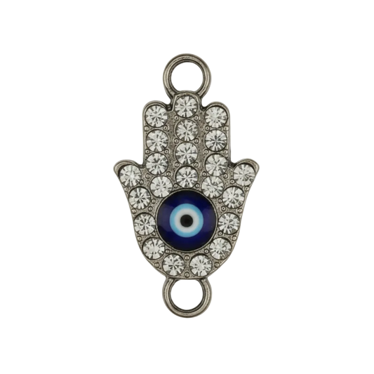 close-up of rhinestone hamsa hand charm with black-and-white eye on black background