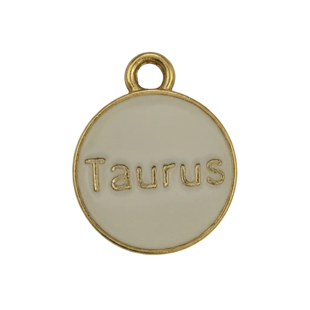 Close-up of a round gold-tone disc charm engraved “Taurus”.