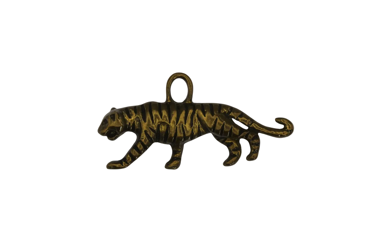 close-up of a gold-tone tiger charm on a black background