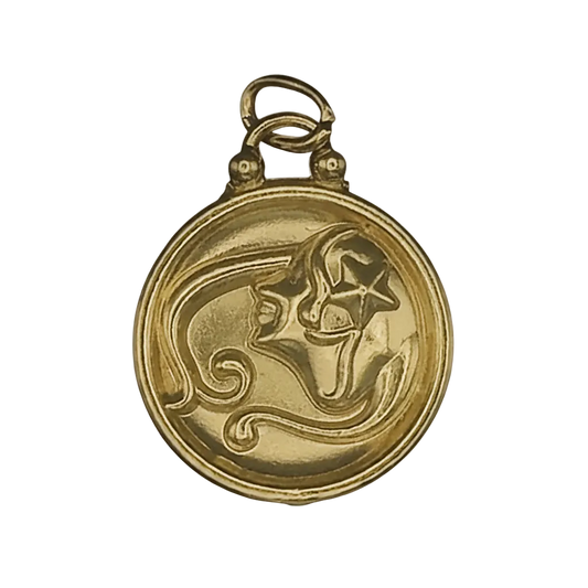 close-up of a round gold-tone charm with a raised face and star motif on black background