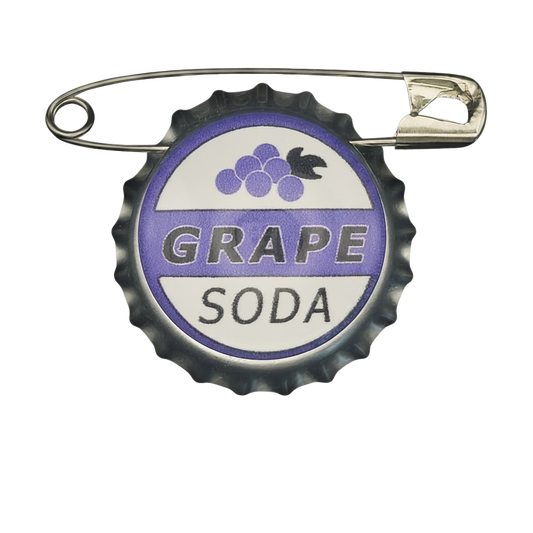 front view of grape soda bottle cap pin with purple and white graphic on black background
