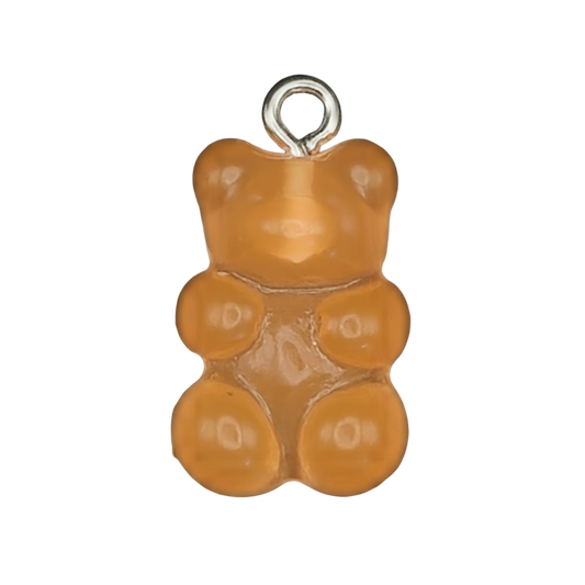 close-up of an orange gummy bear charm on a black background