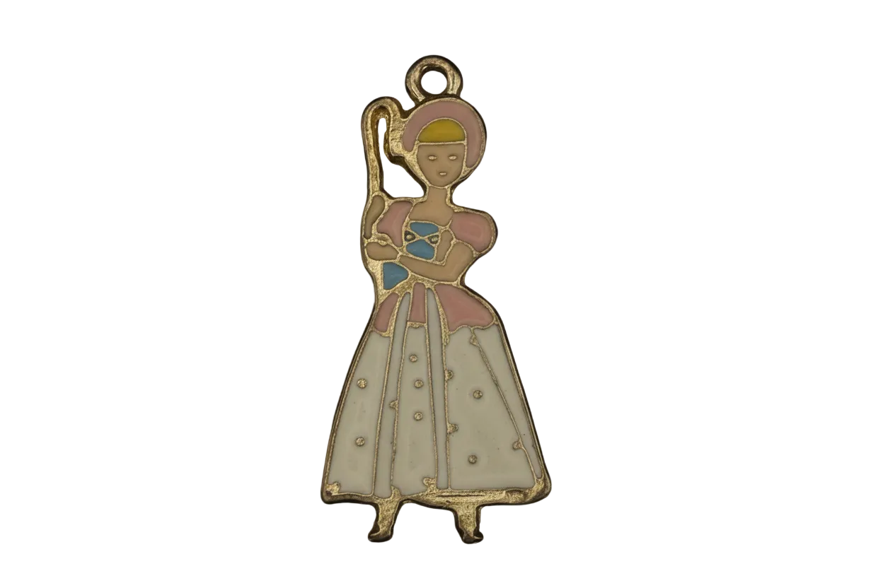gold-tone enamel charm of a shepherdess with bonnet and crook in a pink and white dress on a black background