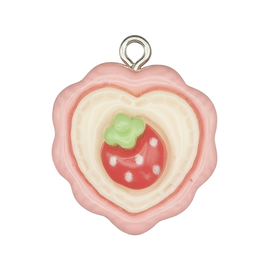 Close-up of pink heart cookie charm with a strawberry center on a black background.