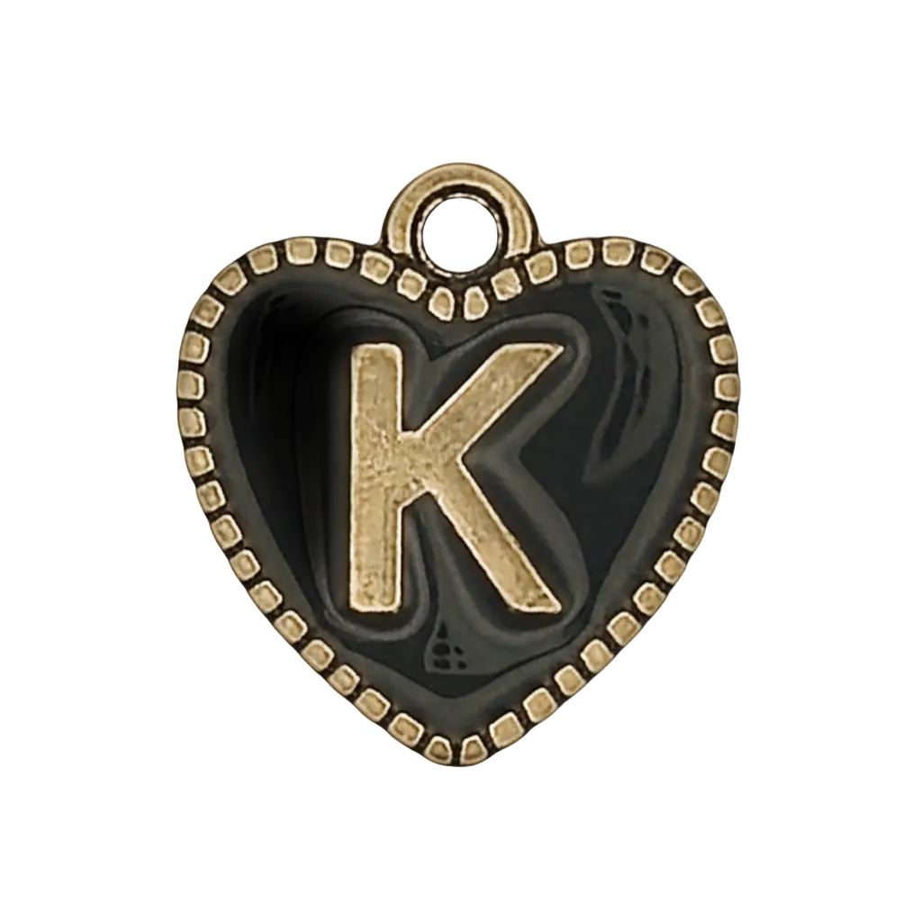 close-up of a black heart-shaped charm with a raised gold letter K and dotted gold border