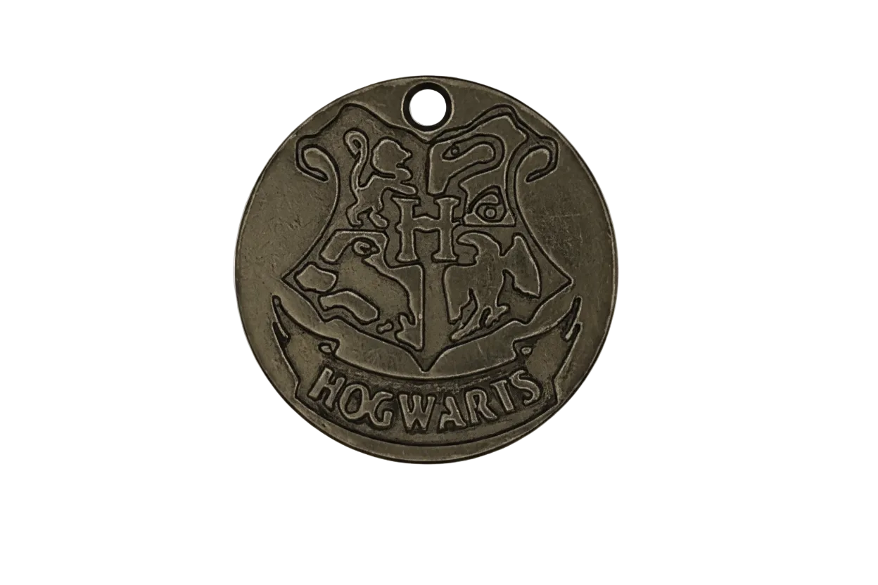 close-up of a round bronze charm with a raised crest and the word HOGWARTS