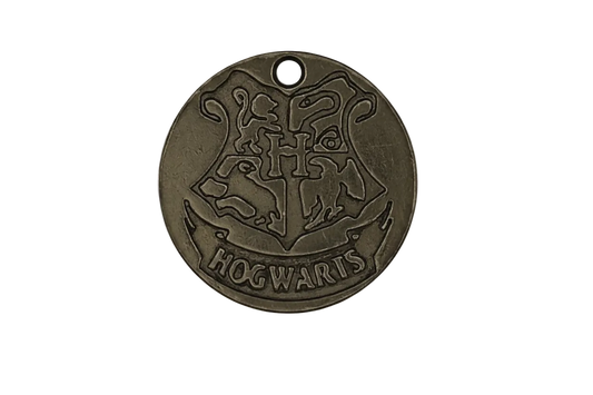 close-up of a round bronze charm with a raised crest and the word HOGWARTS