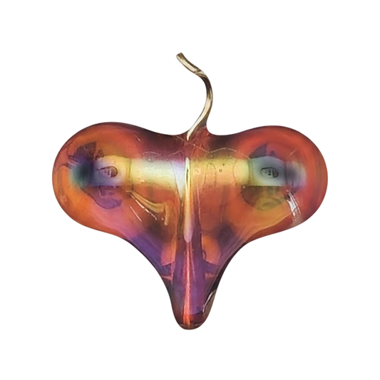 close-up of an iridescent glass heart charm on a black background