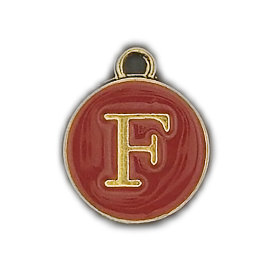 close-up of round red enamel charm with gold letter F