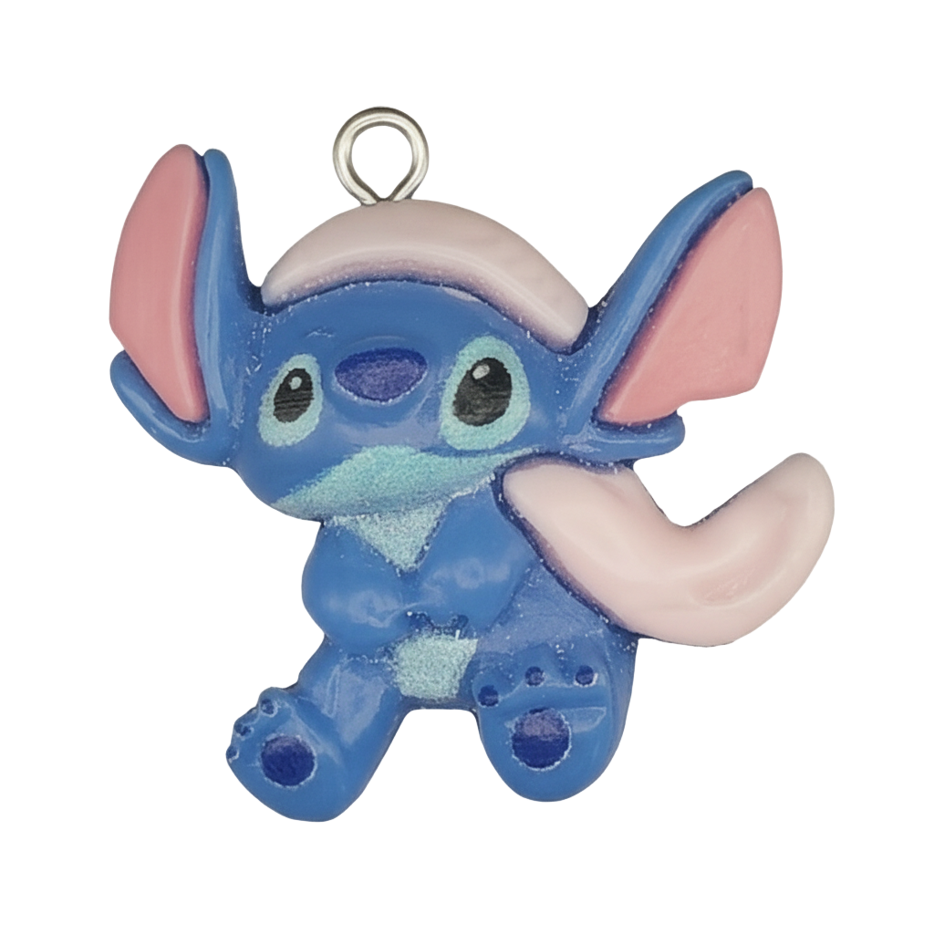 close-up of blue cartoon alien charm with large pink ears on black background