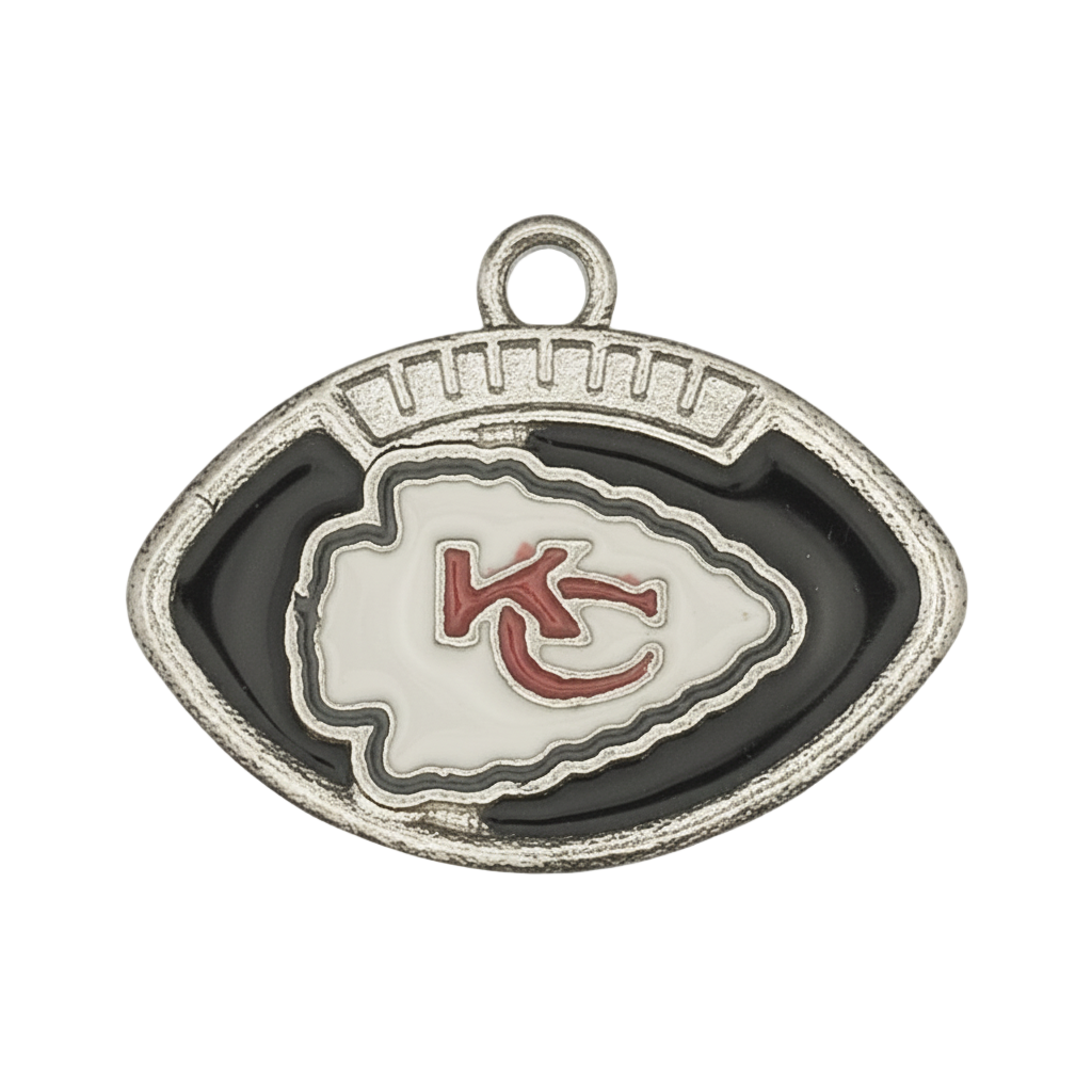 close-up of football-shaped metal charm with black enamel and white arrowhead showing red 'KC' letters