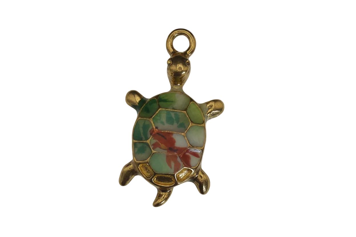 Close-up of a gold-tone turtle charm with a green and red shell on a black background.