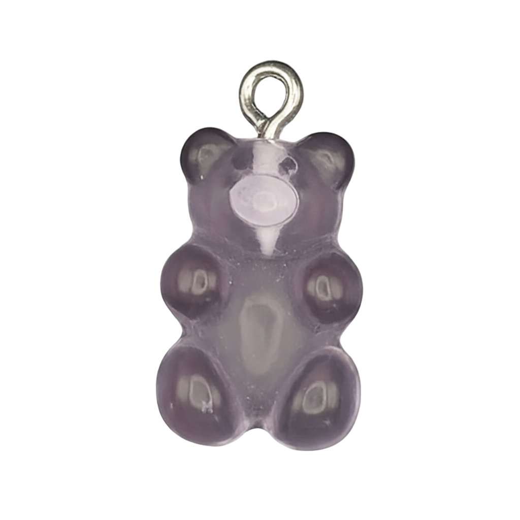 close-up of a small purple gummy bear-shaped charm on a black background