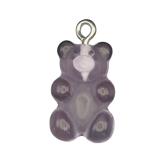 close-up of a small purple gummy bear-shaped charm on a black background