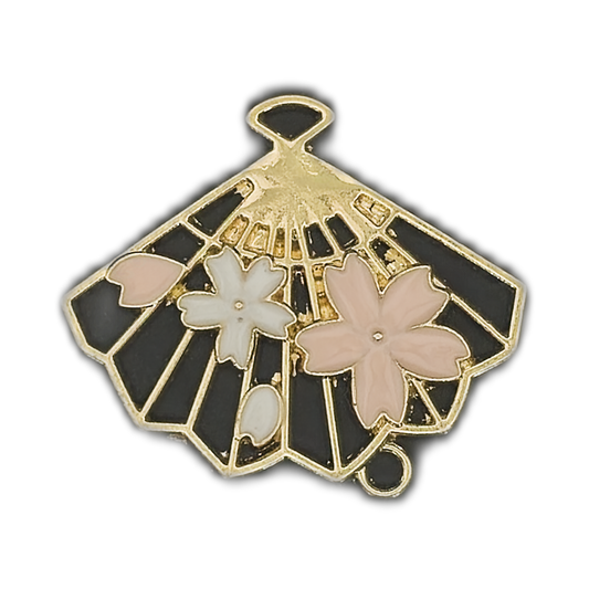 Gold-tone fan charm with black enamel and pink and white cherry blossoms, close-up.