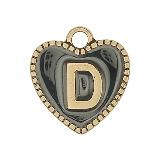 close-up of a heart-shaped charm with gold letter D on black background