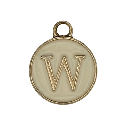 close-up of round ivory and gold charm with letter W