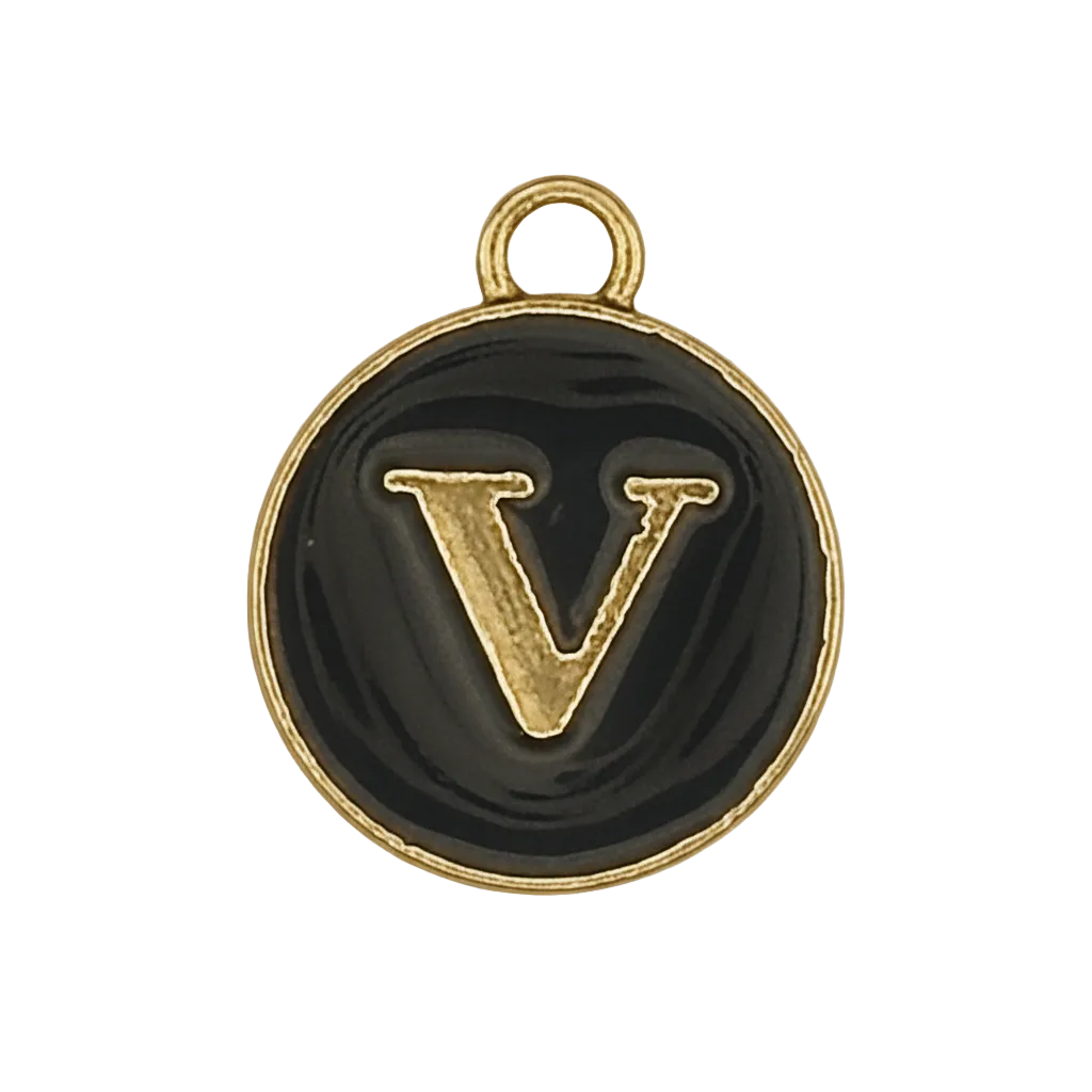 close-up of small round black charm with raised gold letter V
