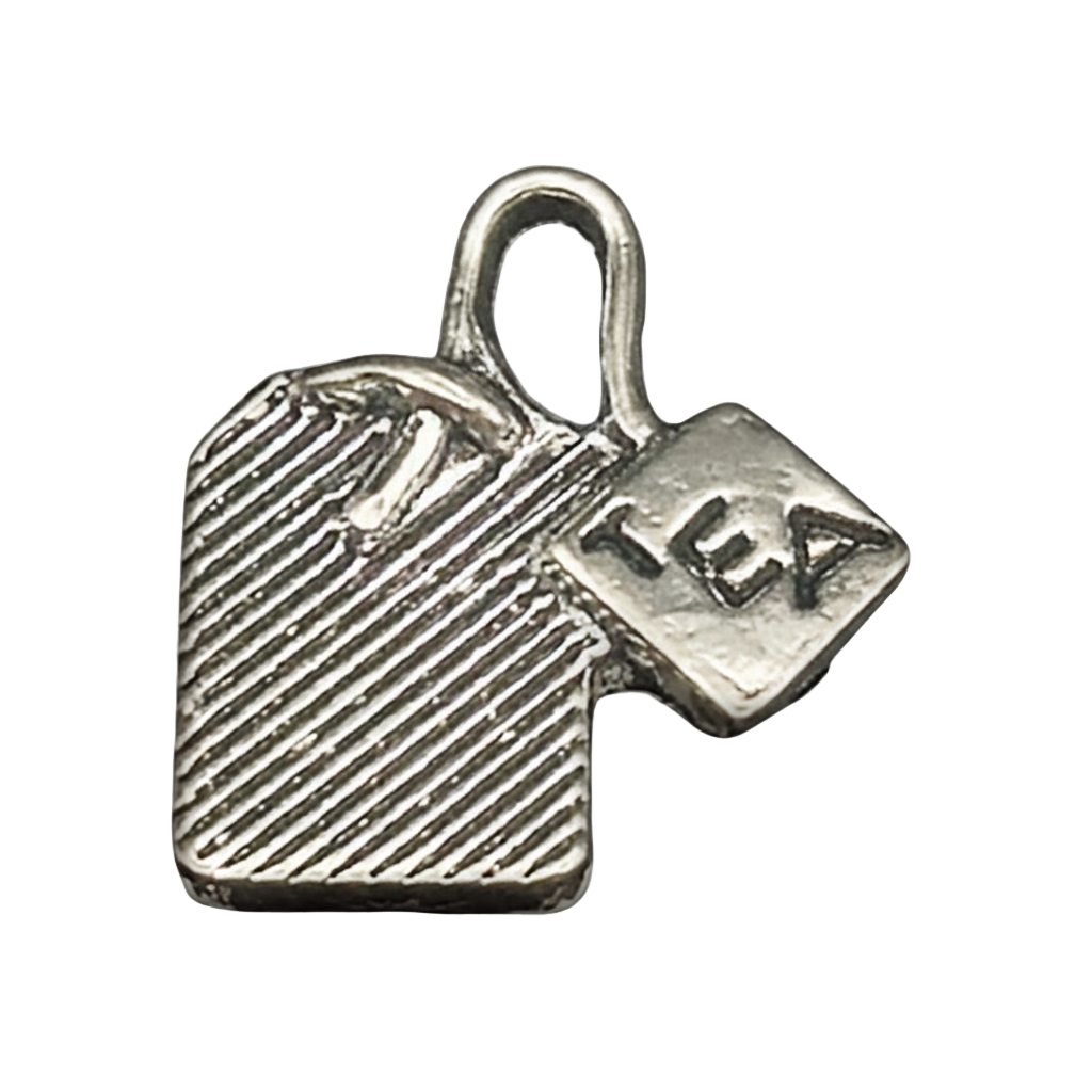 Close-up of a silver tea bag charm with a tag reading "TEA" on a black background.