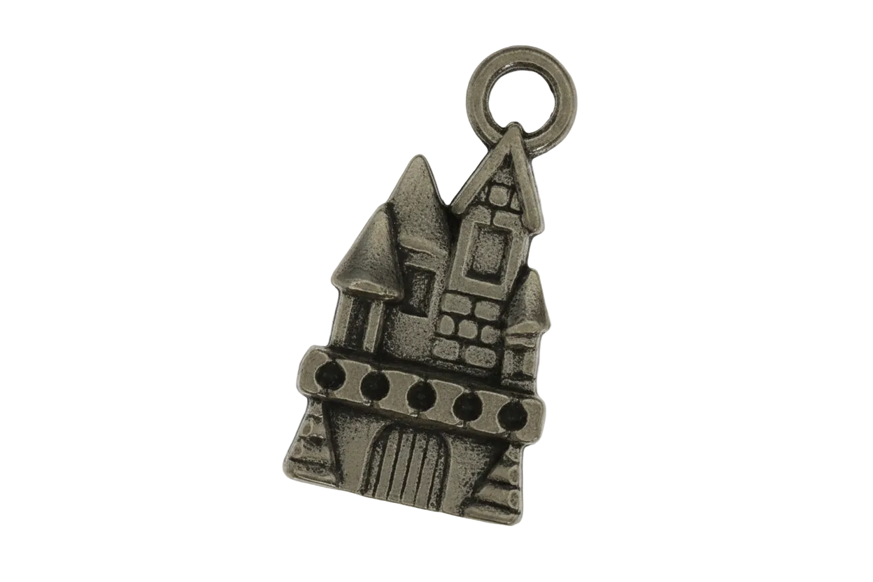 close-up of a small bronze castle charm on a black background