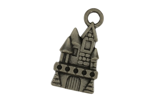 close-up of a small bronze castle charm on a black background