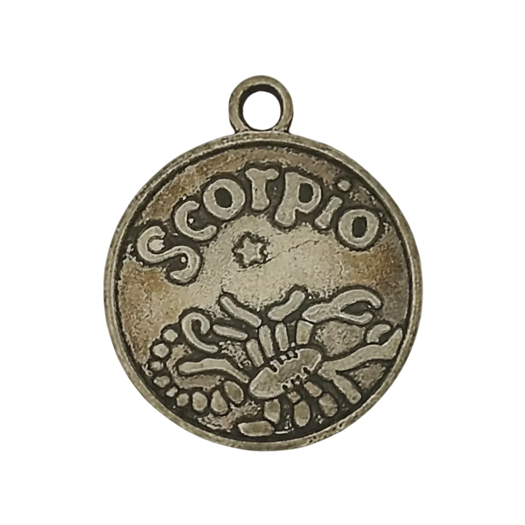 close-up of round metal charm reading 'scorpio' with scorpion design on black background