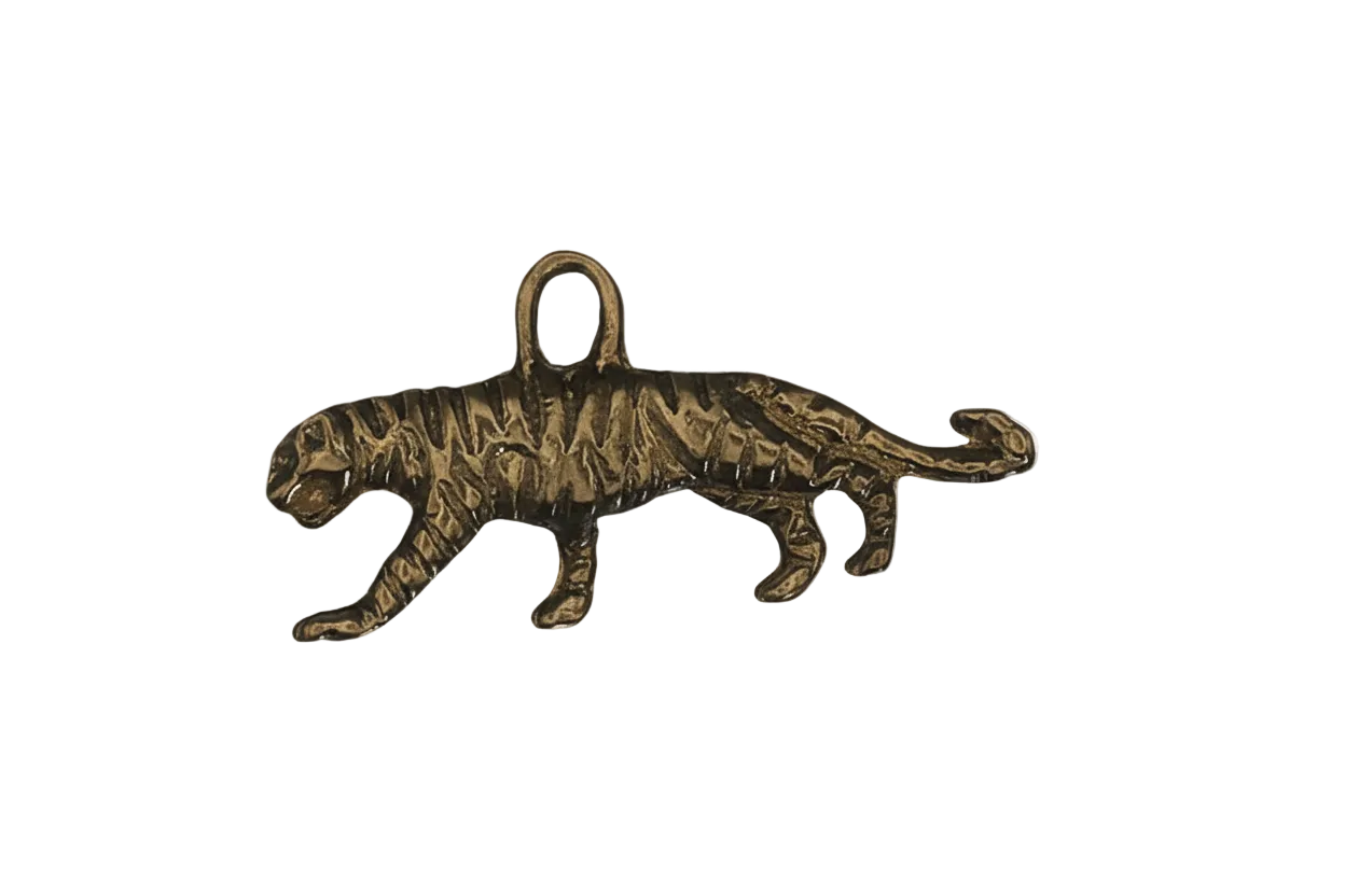 close-up of gold-tone walking tiger charm on black background