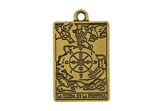 Close-up of rectangular gold-tone tarot charm reading 'La Rueda de la Fortuna' on a black background.