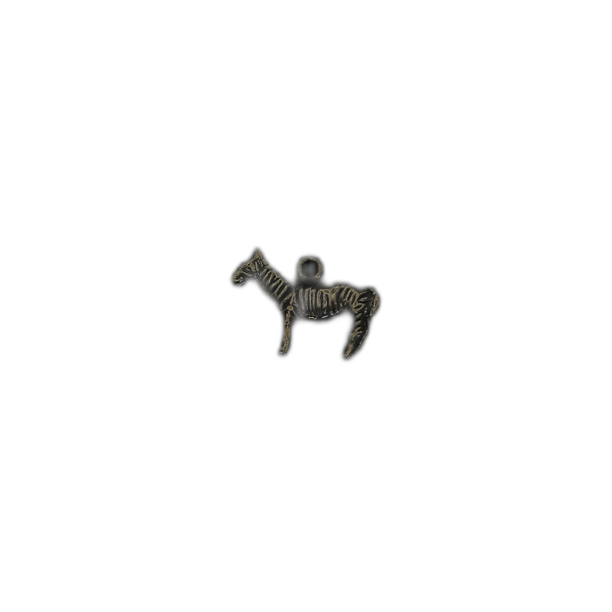 zebra-shaped metal charm on black background