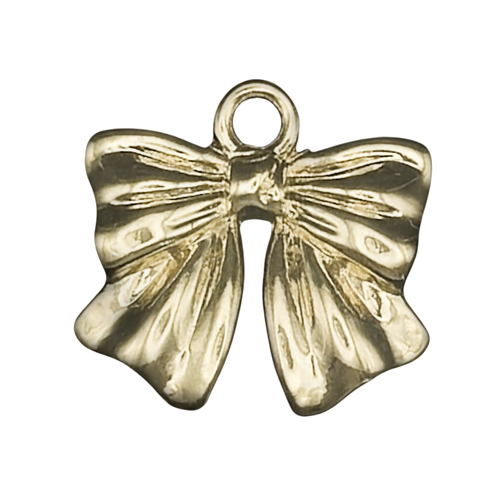 close-up of small gold bow charm on black background