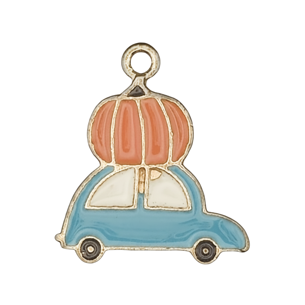 Close-up of an enamel charm showing an orange pumpkin on top of a blue car with gold outline on a black background.