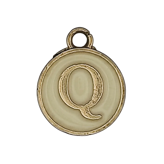 close-up of round cream charm with gold letter Q