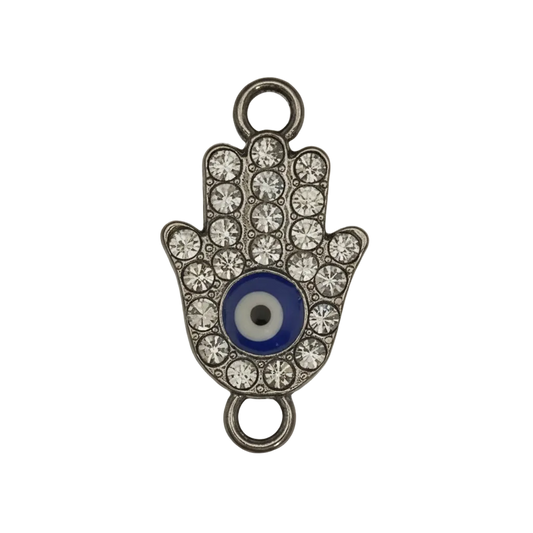 close-up of a rhinestone hamsa hand charm with blue evil eye on black background