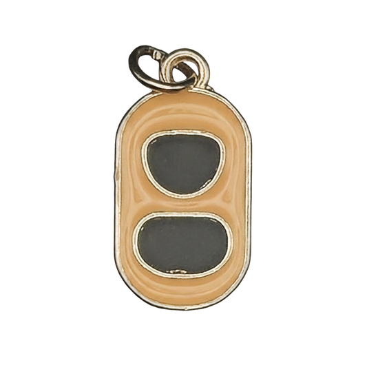 close-up of a gold-tone enamel charm shaped like a soda can tab with two dark gray openings