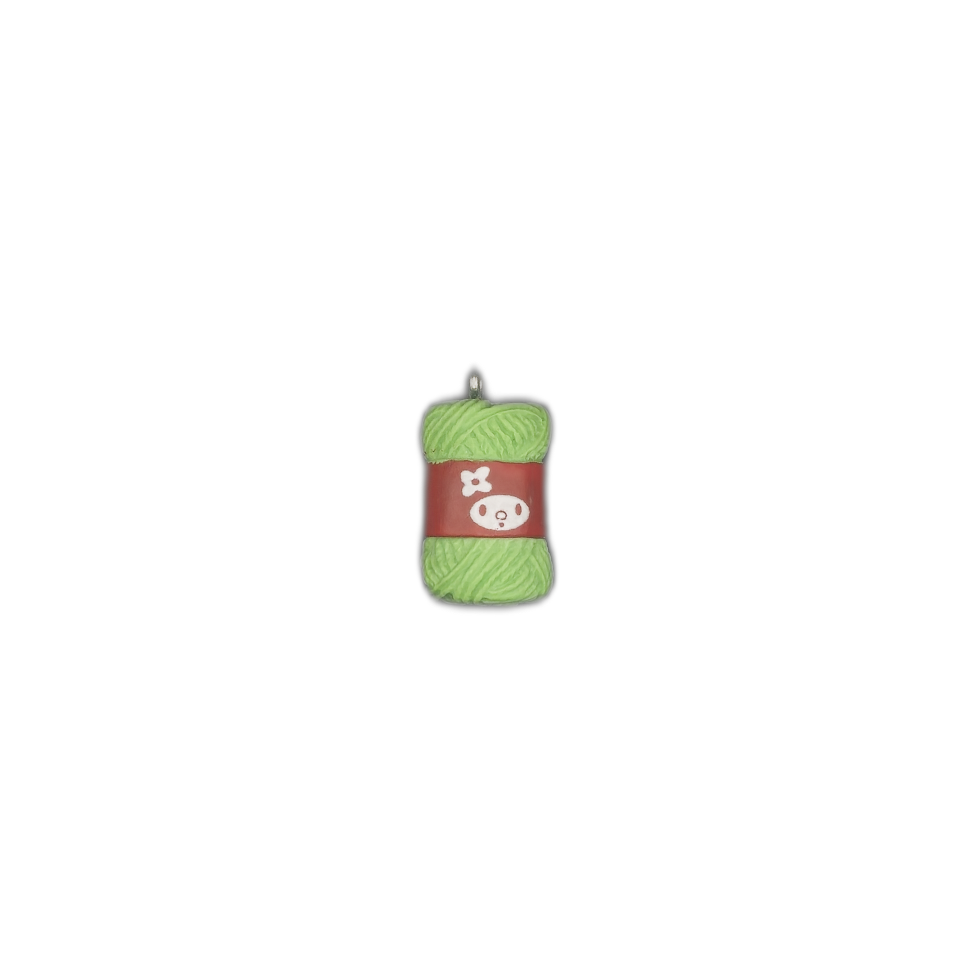 small charm shaped like a green yarn skein with a red label