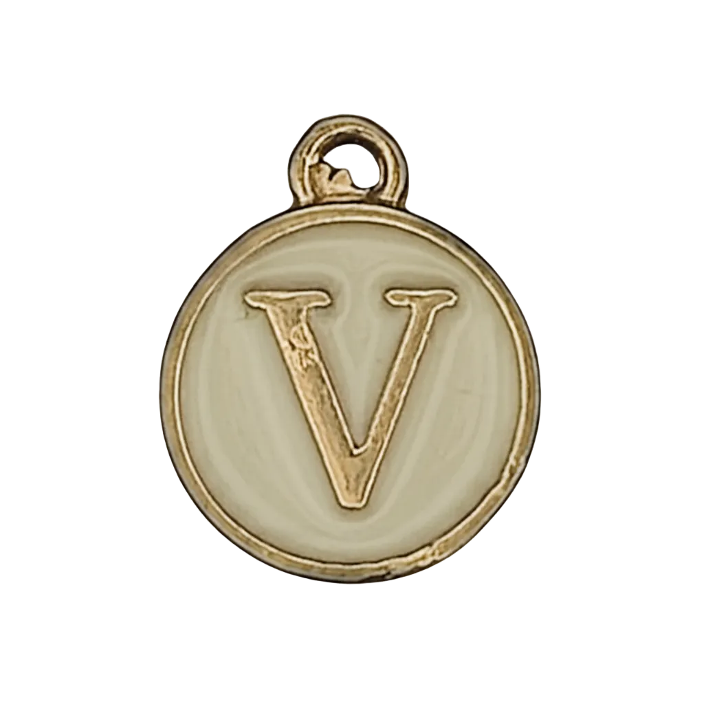Close-up of round cream enamel charm with gold letter V.