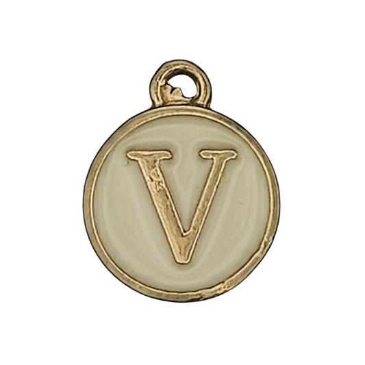 Close-up of round cream enamel charm with gold letter V.