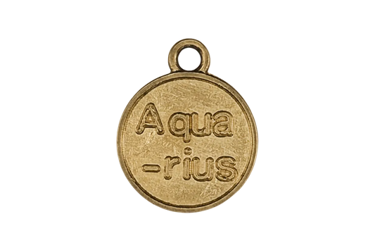 close-up of round gold charm engraved “Aqua-rius” on black background