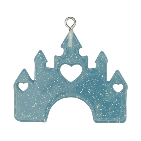 close-up of blue glitter castle charm with heart cutouts on black background