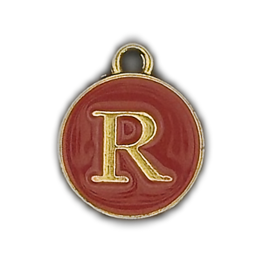 close-up of round red enamel charm with gold letter R on black background