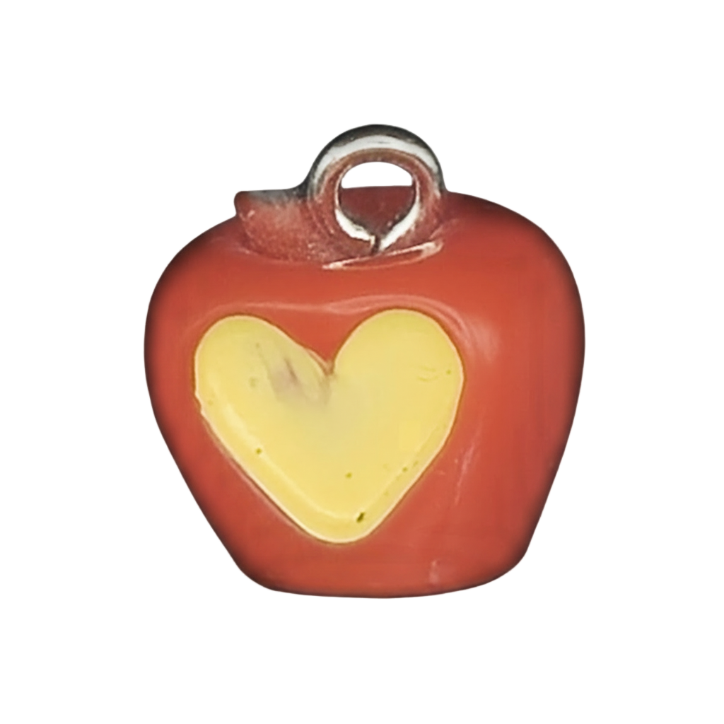 close-up of a small red apple charm with a yellow heart