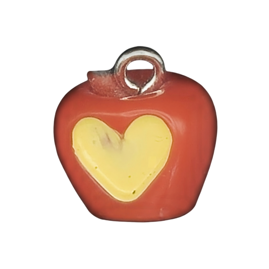 close-up of a small red apple charm with a yellow heart